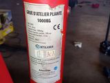 une borne d'incendie rouge sur laquelle est collé un autocollant, dans un garage