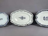 trois assiettes bleues et blanches ornées de motifs floraux sur un fond gris