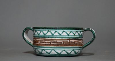 une tasse verte et blanche posée sur une table