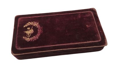 un coffret en velours orné d'un emblème doré