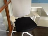 a black and white office chair in front of a window