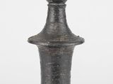 un vase noir posé sur une surface blanche