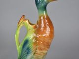 un petit canard en céramique posé sur une table
