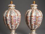 paire de vases chinois ornés de motifs floraux, posés sur des socles, sur fond gris
