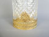 un vase en verre surmonté d'une couronne dorée