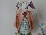 a figurine of a woman standing next to a bird