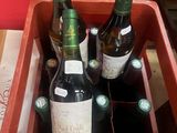 several bottles of wine are in a red box on a table