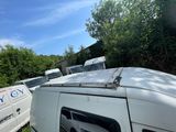 a van that is parked in the grass next to a van