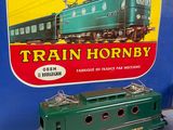 a green train engine sitting next to a box of train hornby
