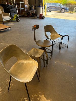 trois chaises dans un garage, avec une voiture en arrière-plan
