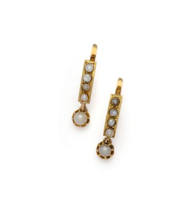 une photo d'une paire de boucles d'oreilles en or ornées de pierres blanches
