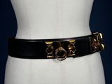 a close up of a mannequin torso wearing a black belt with gold buckles