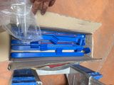 a box of tools sitting on the floor next to a person ' s hand