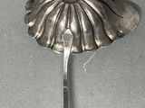 a spoon with a flower on it sitting on a table