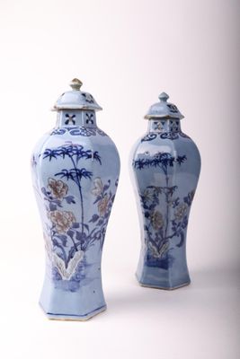 une paire de vases bleus et blancs ornés de fleurs sur un fond blanc