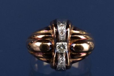 une bague en or sertie d'un diamant, posée sur un fond bleu