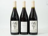 trois bouteilles de vin sont alignées sur une surface blanche