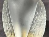 a glass bird figurine sitting on a table