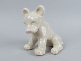 une petite figurine de chat blanc posée sur une table