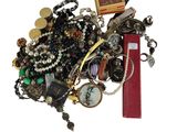 une pile de bijoux assortis sur une surface blanche