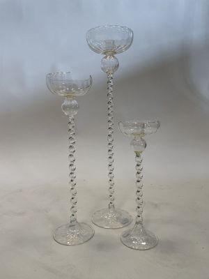 three clear glass wine glasses sitting on top of a white table