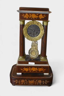 une horloge posée sur un support sur une surface blanche