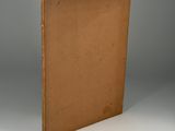 an old book with a brown cover sitting on top of a white table