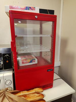 une vitrine rouge contenant du pain, posée sur un comptoir