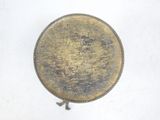 a gold plate with a cross on it sitting on a white surface