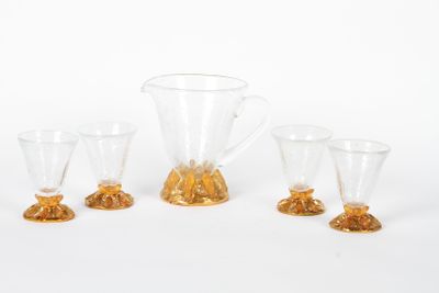 trois verres transparents et un pichet posés les uns à côté des autres sur une surface blanche