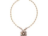 un collier en or avec un pendentif en forme de fleur au bout d'une chaîne