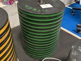une grande pile de tuyaux noirs et verts posée par terre