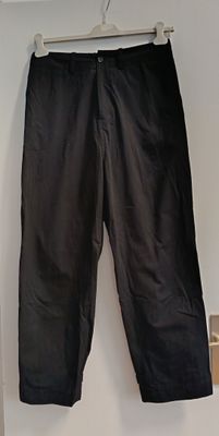 a black pants hanging on a hanger in a room