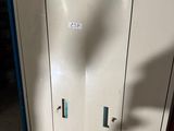 une armoire métallique surmontée d'une horloge, dans une pièce