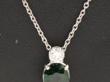 un pendentif en émeraude et diamant sur une chaîne en argent