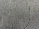 un collier en argent surmonté d'un petit coffret rouge