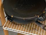 a black pan sitting on a shelf in a kitchen