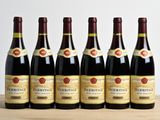 six bouteilles de vin sont alignées sur une table en bois