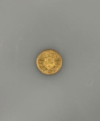 gros plan d'une pièce d'or sur une surface blanche