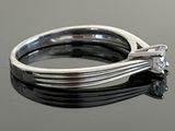 a close up of a diamond ring on a black surface