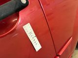 a sticker on the door handle of a red car