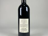a bottle of red wine sitting on top of a white table