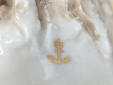 a close up of a figurine of a man with an anchor on it ' s head