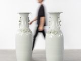 deux grands vases posés par terre devant un homme