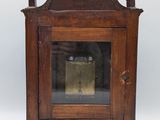 an old wooden clock with a glass door on a white background