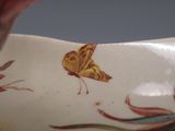 un gros plan d'un vase sur lequel est peint un papillon