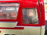 a red and white bus with a man inside of it