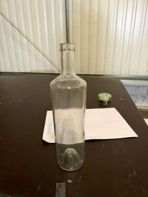 a bottle of water sitting on a table next to a piece of paper