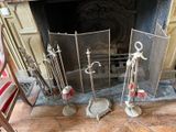 une cheminée sur laquelle sont posés un foyer et un ensemble de balais