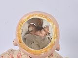 a small doll that has a mirror on it ' s head